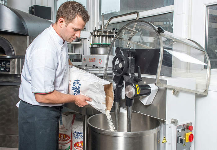 homme versant de la farine dans le pétrin